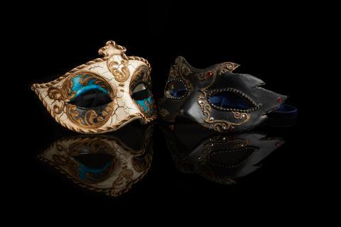 Two masquerade masks on a black background.
