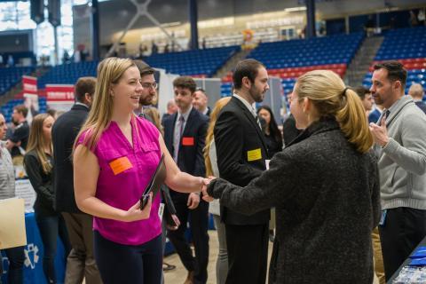 学生 and alumni greeting potential employers at a career fair