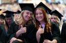 两个女学生在毕业典礼上竖起大拇指